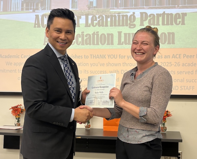 Dr. Tolentino poses with a student holding Peer Learning Partner award.