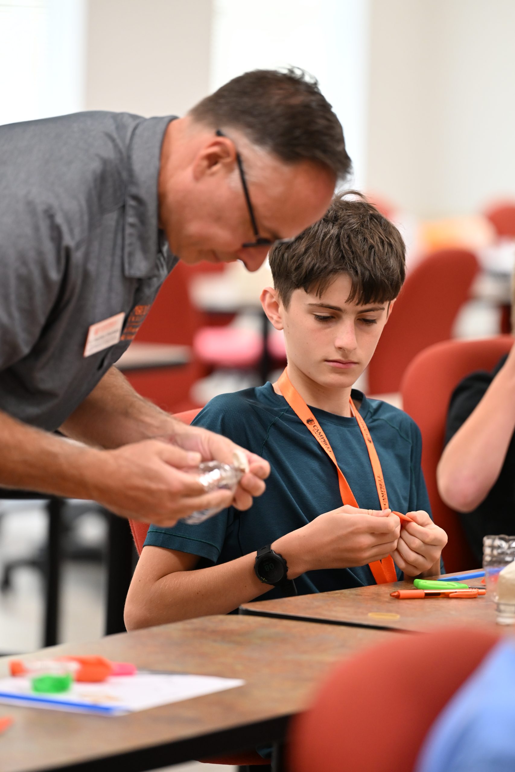 Campbell University faculty member assists a middle school STEM Camp participant during a hands-on science activity.