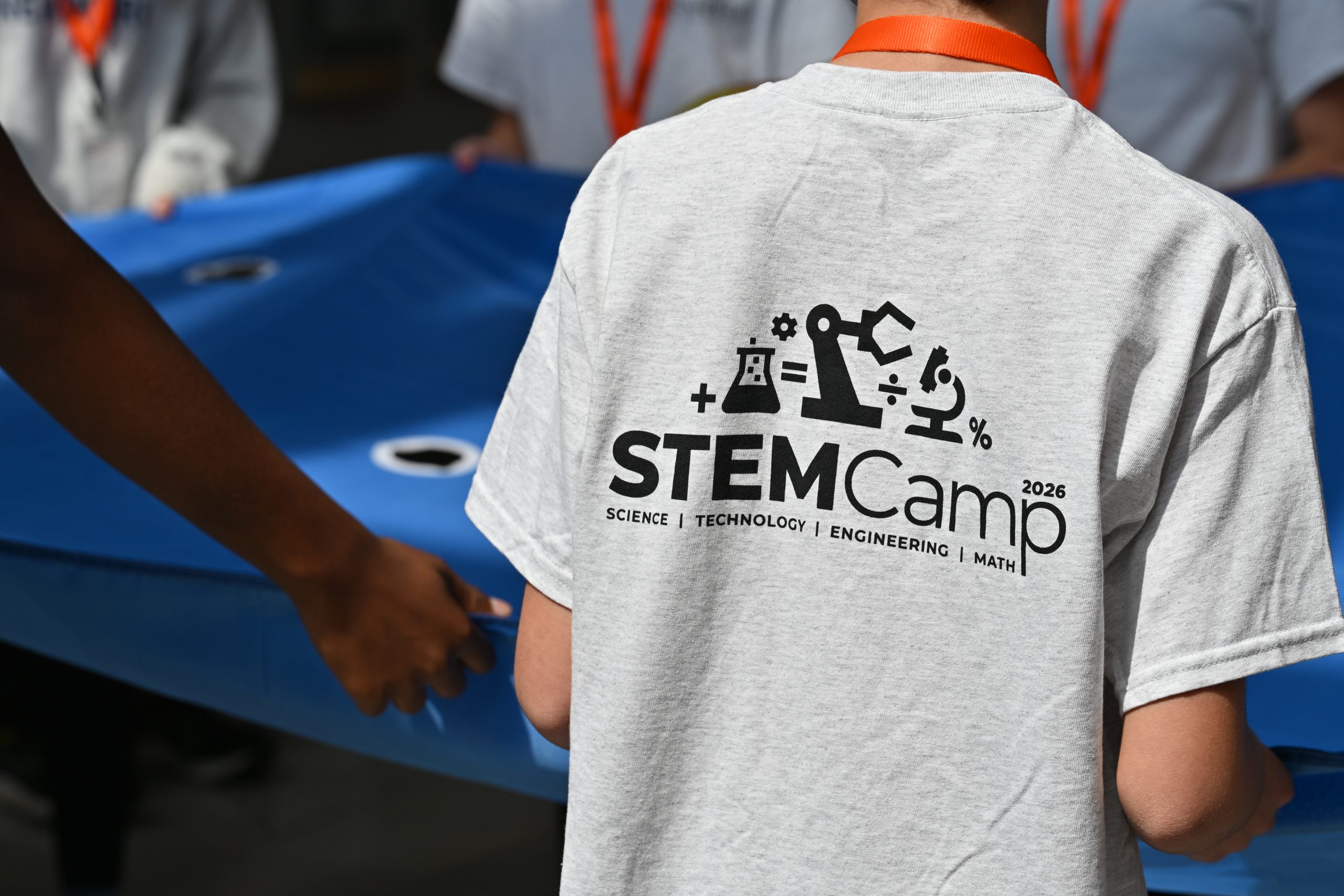 The back of a Campbell University STEM Camp 2026 T-shirt as participants take part in a group activity.