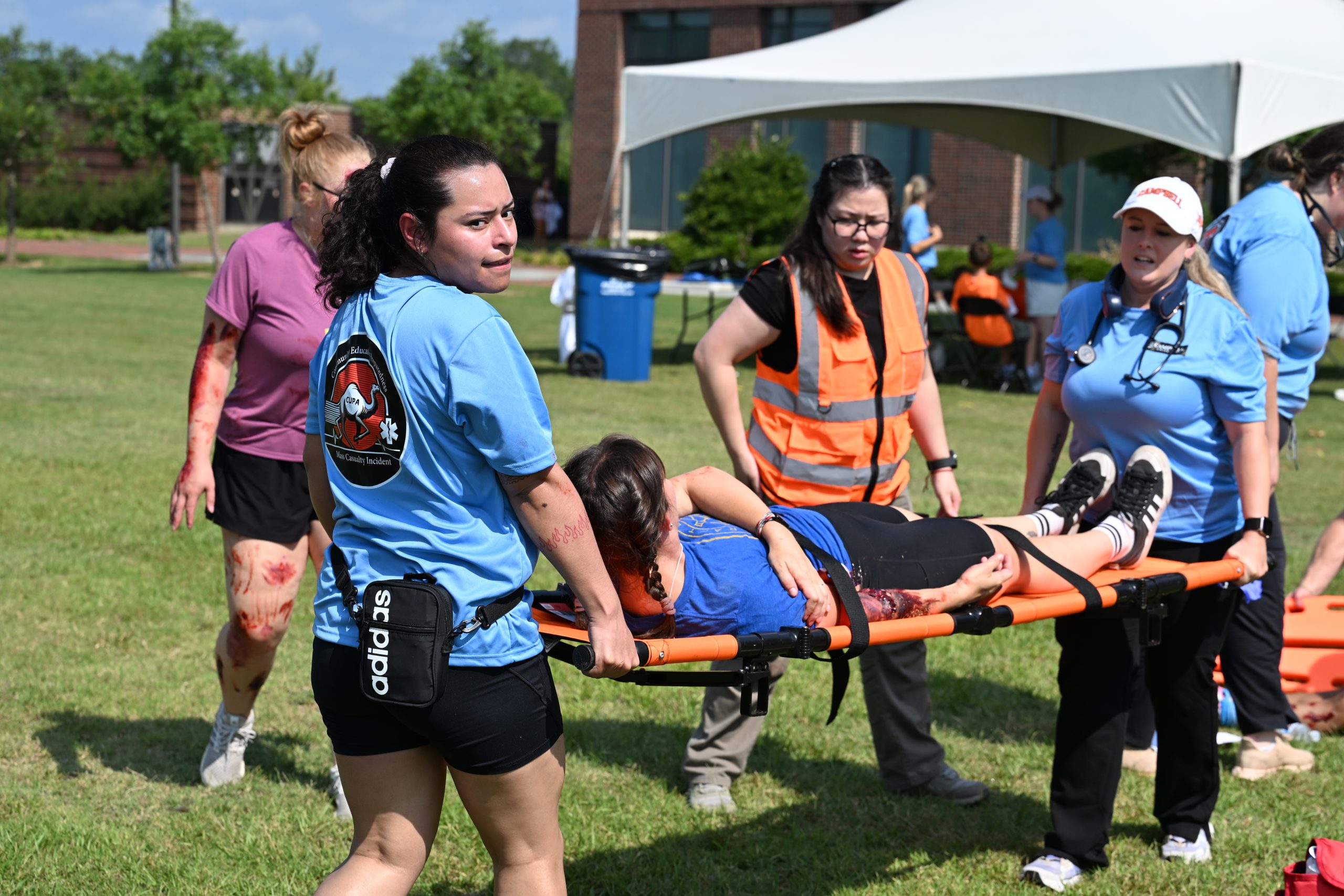 Two female PA students carry a litter with a female patient