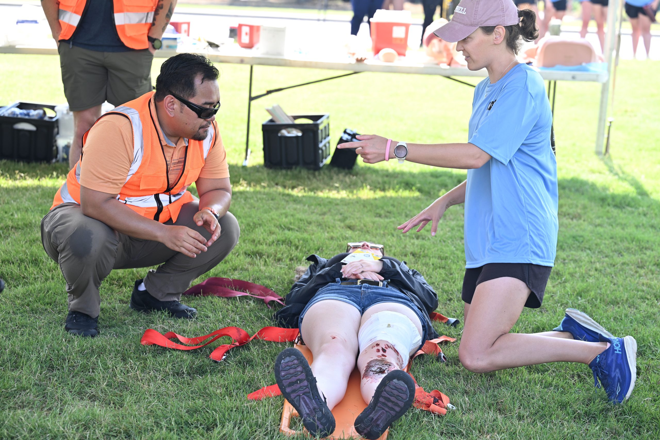 Female PA student telling EMT the next steps in treating an injured patient.