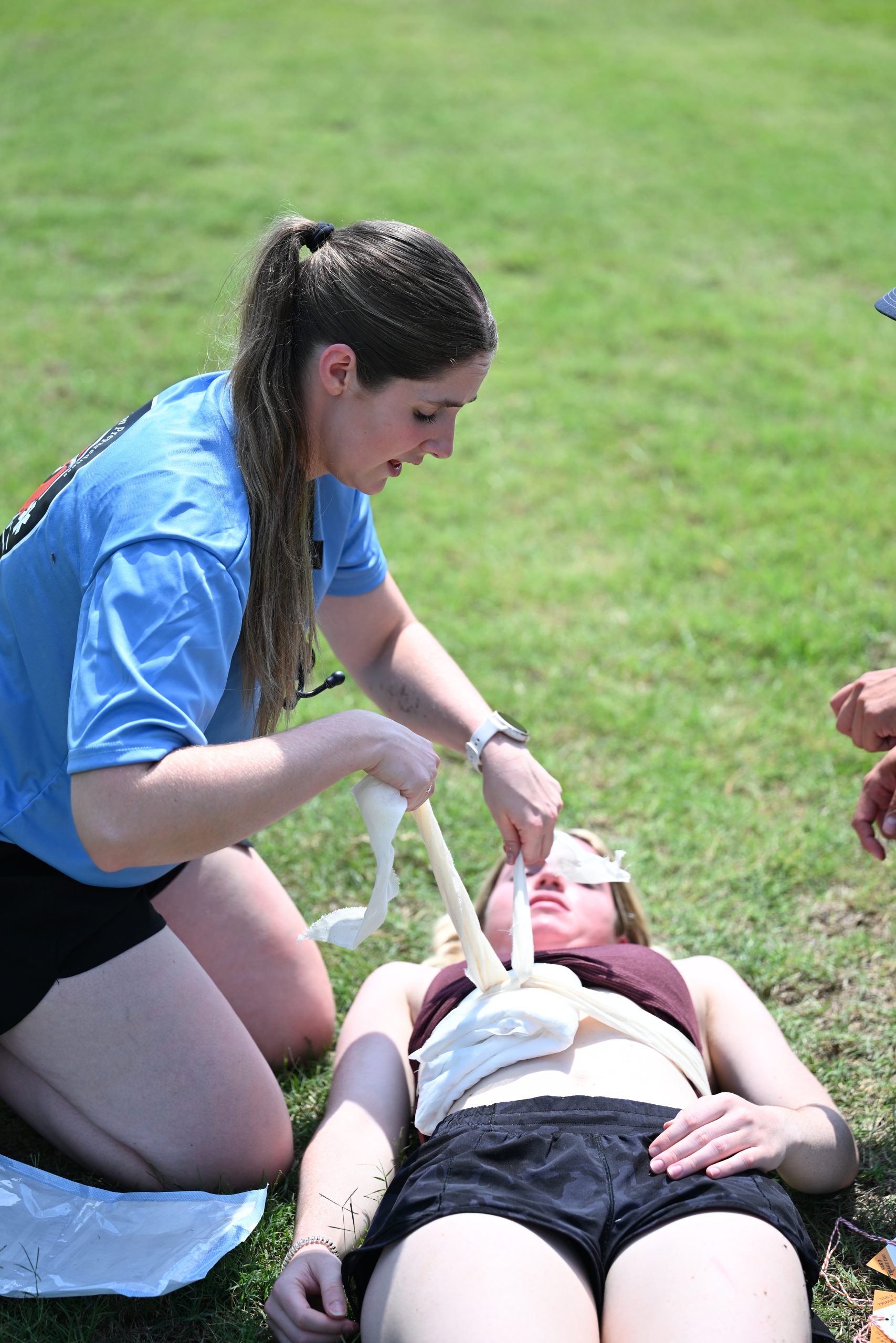 Female PA student ties bandage on patient