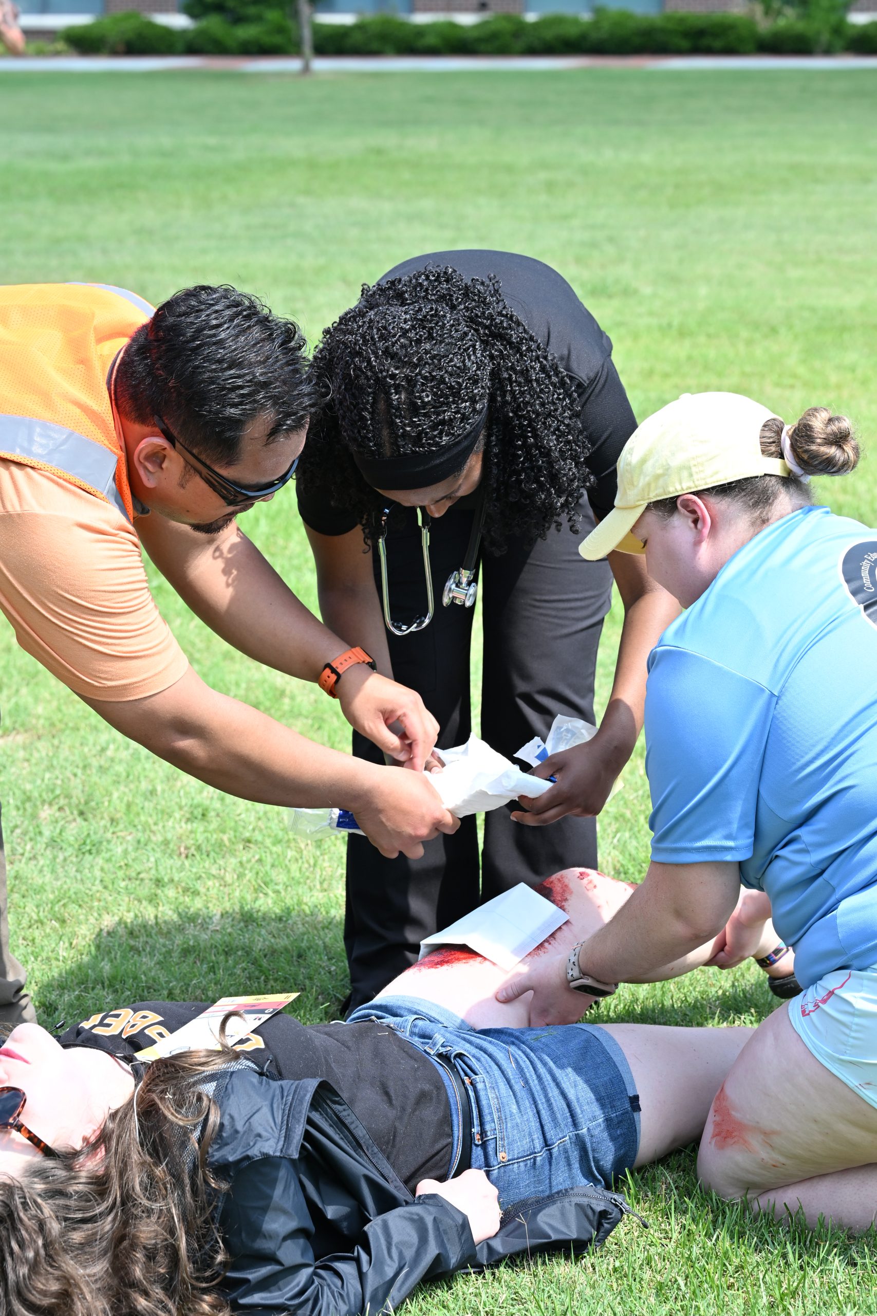 Two PA students get instruction on treating a wound.