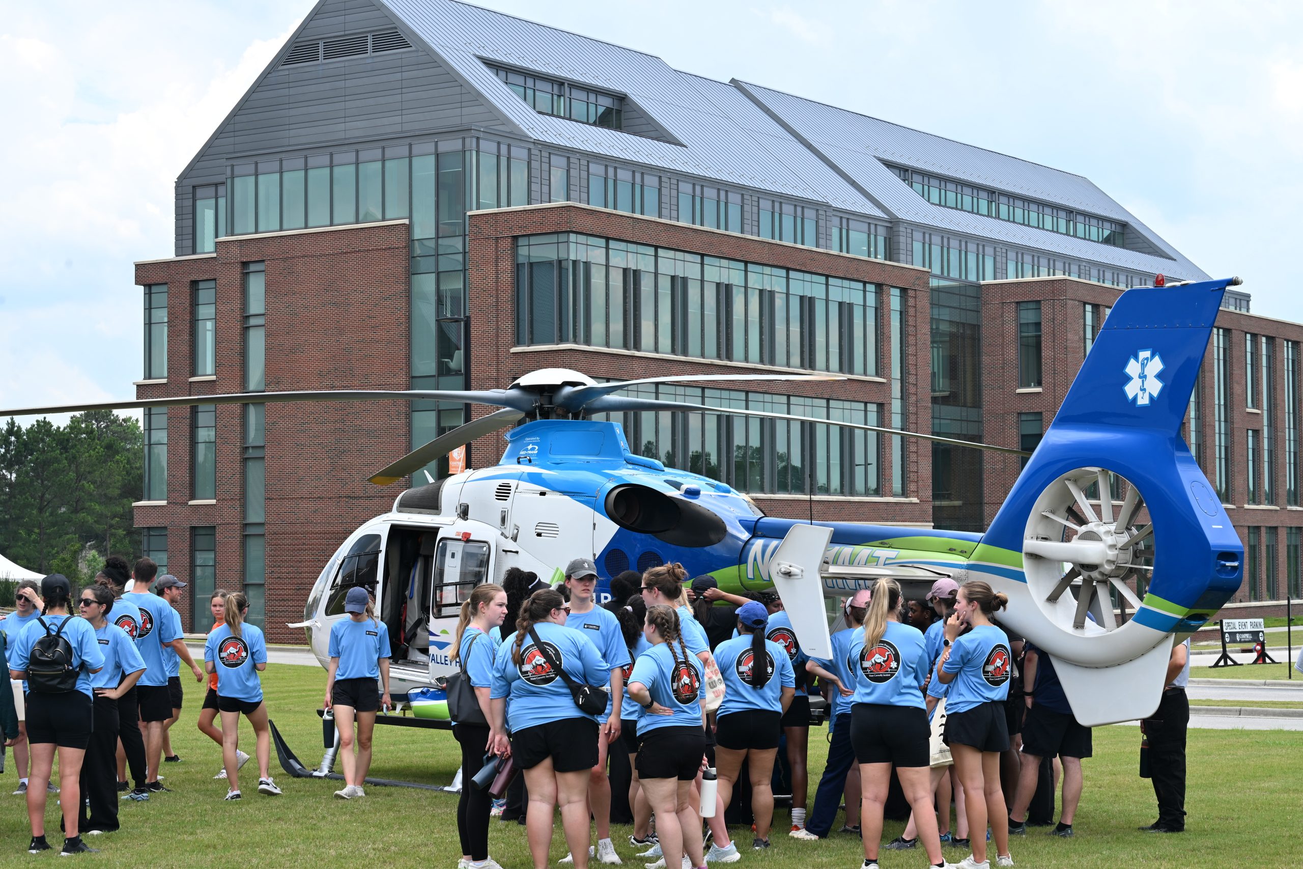 Large group of PA students surrounding the lifelink helicopter talking with the flight crew