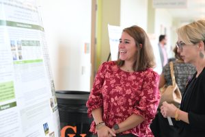 Student talks with faculty member about her poster.