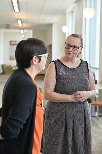 A student presents a research poster while discussing her project with an attendee during a poster session at the Campbell University College of Pharmacy & Health Sciences.
