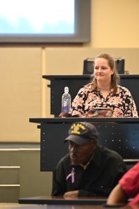 An attendee listens attentively during a presentation in a lecture hall at the Campbell University College of Pharmacy & Health Sciences.