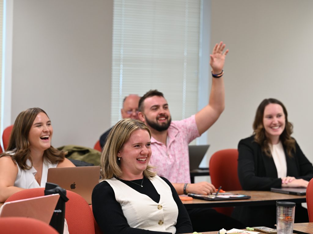 Student raising hand with everyone laughing