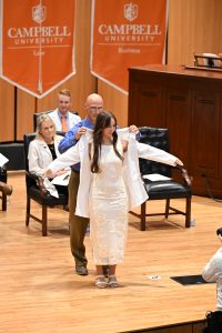 Student being coated on stage