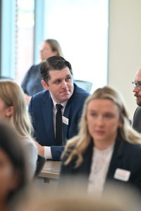 Student leaning forward and looking at the student beside him in conversation