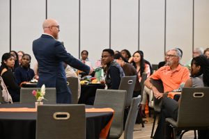 A presenter speaks to an audience of students, faculty and guests during a Campbell University College of Pharmacy & Health Sciences event.