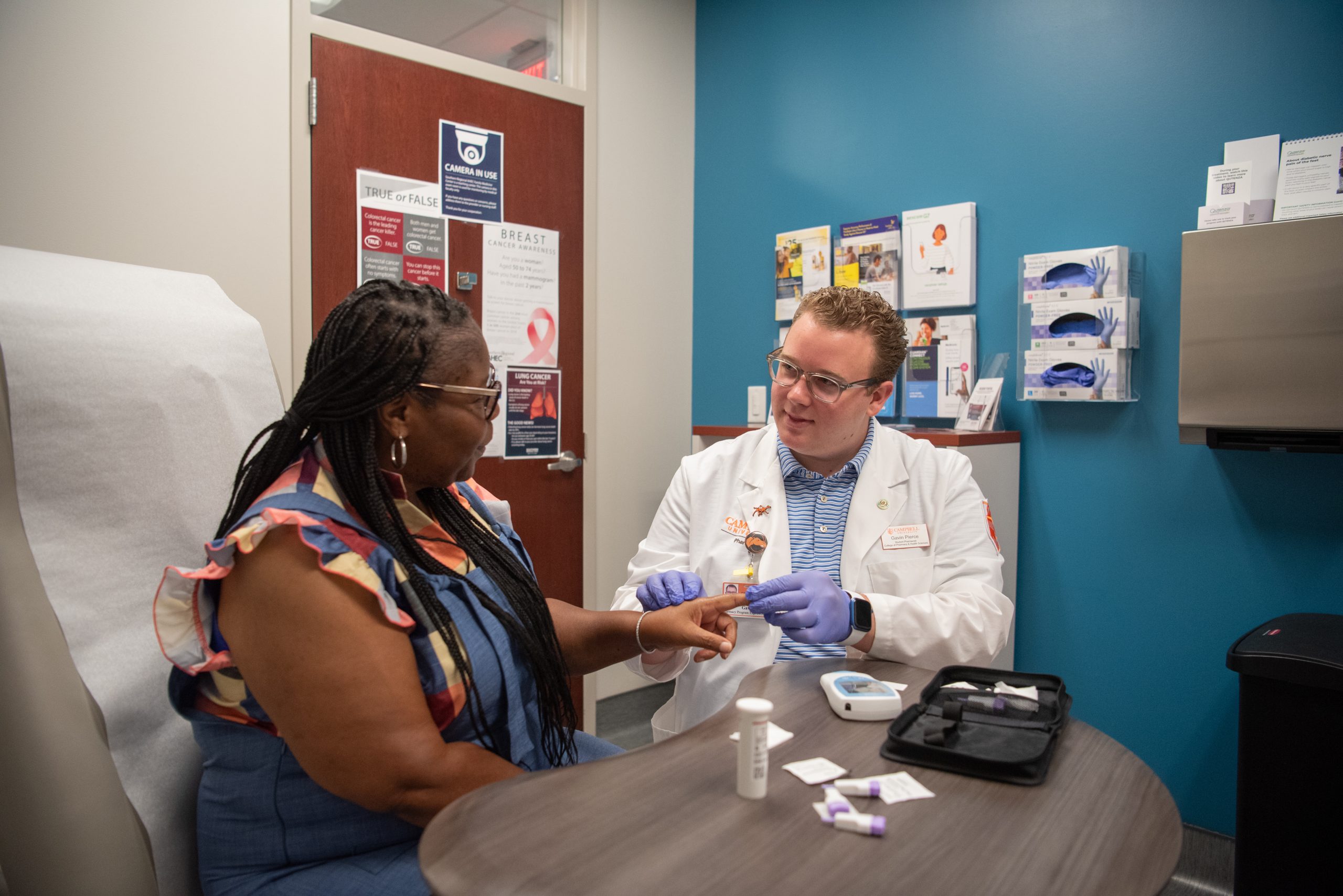 Student teaching patient how to check her blood sugar