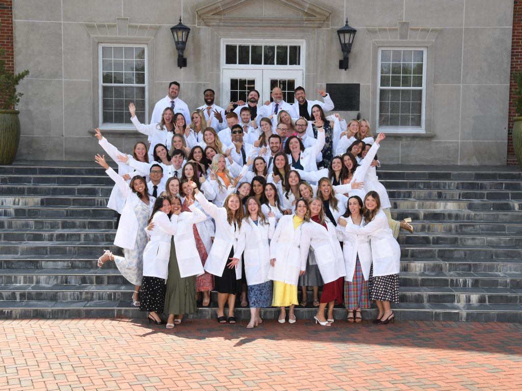 PA Class of 2026 wearing their long whit coats posing for a fun photo