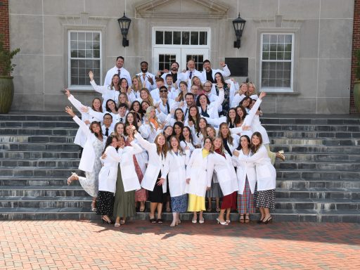 PA Class of 2026 wearing their long whit coats posing for a fun photo