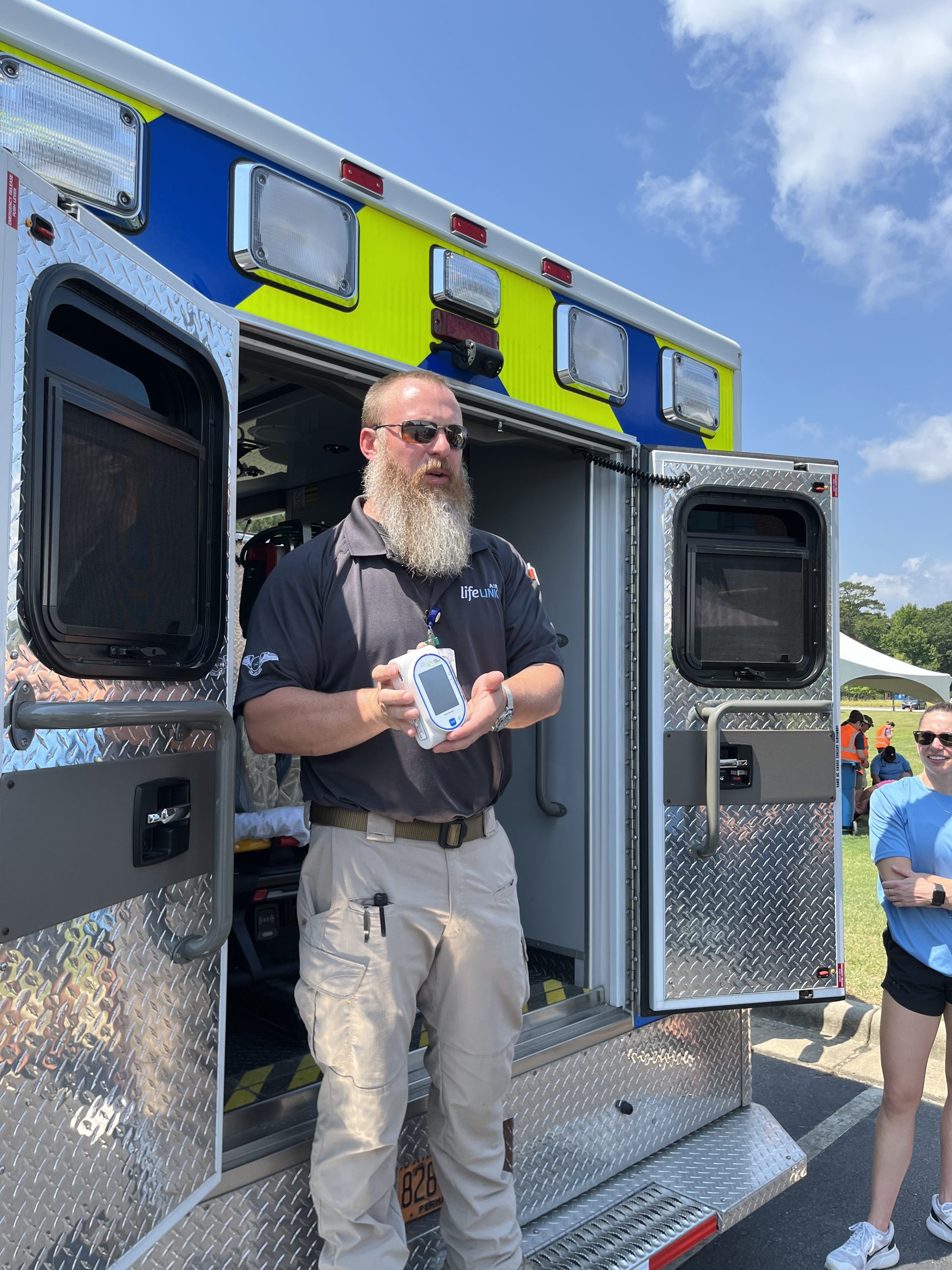 Male EMT talks with students about equipment on the truck
