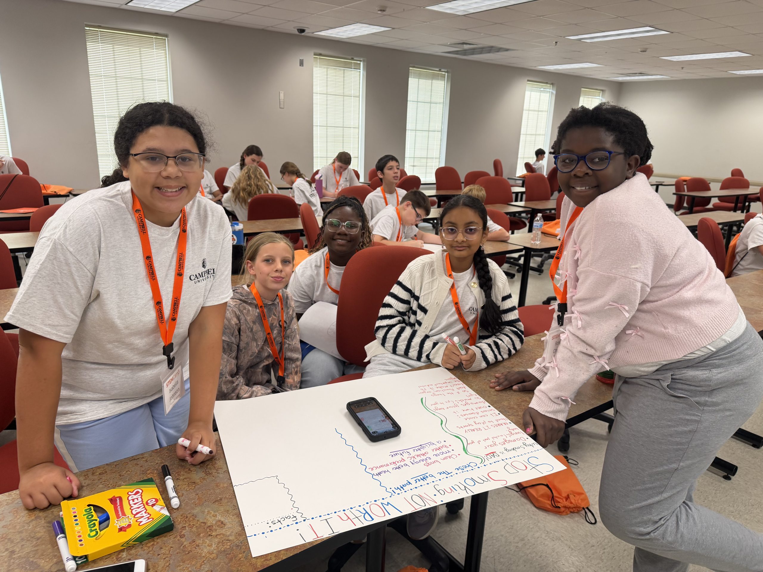 Middle school STEM Camp participants gather around a table to collaborate on a team activity at Campbell University.