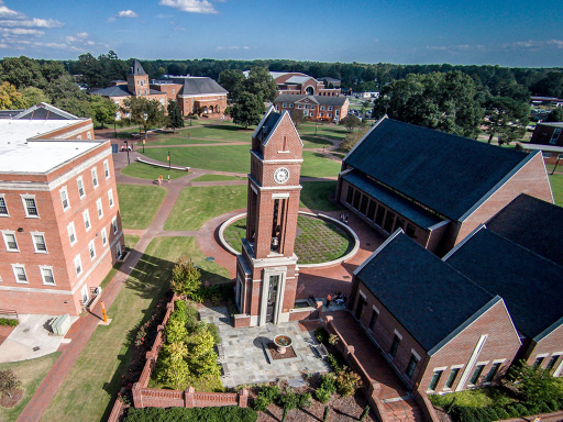 Aerial view of Campbell University's campus surrounded by academic buildings, green lawns and brick walkways.