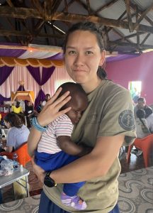 Med school student holds baby in Kenya