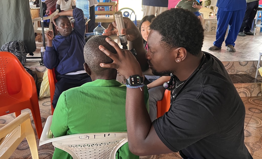 Med school students in Kenya examine patient