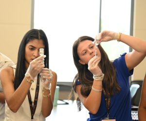 Two students carefully prepare medication doses with syringes during a hands-on pharmacy skills activity at Campbell University.