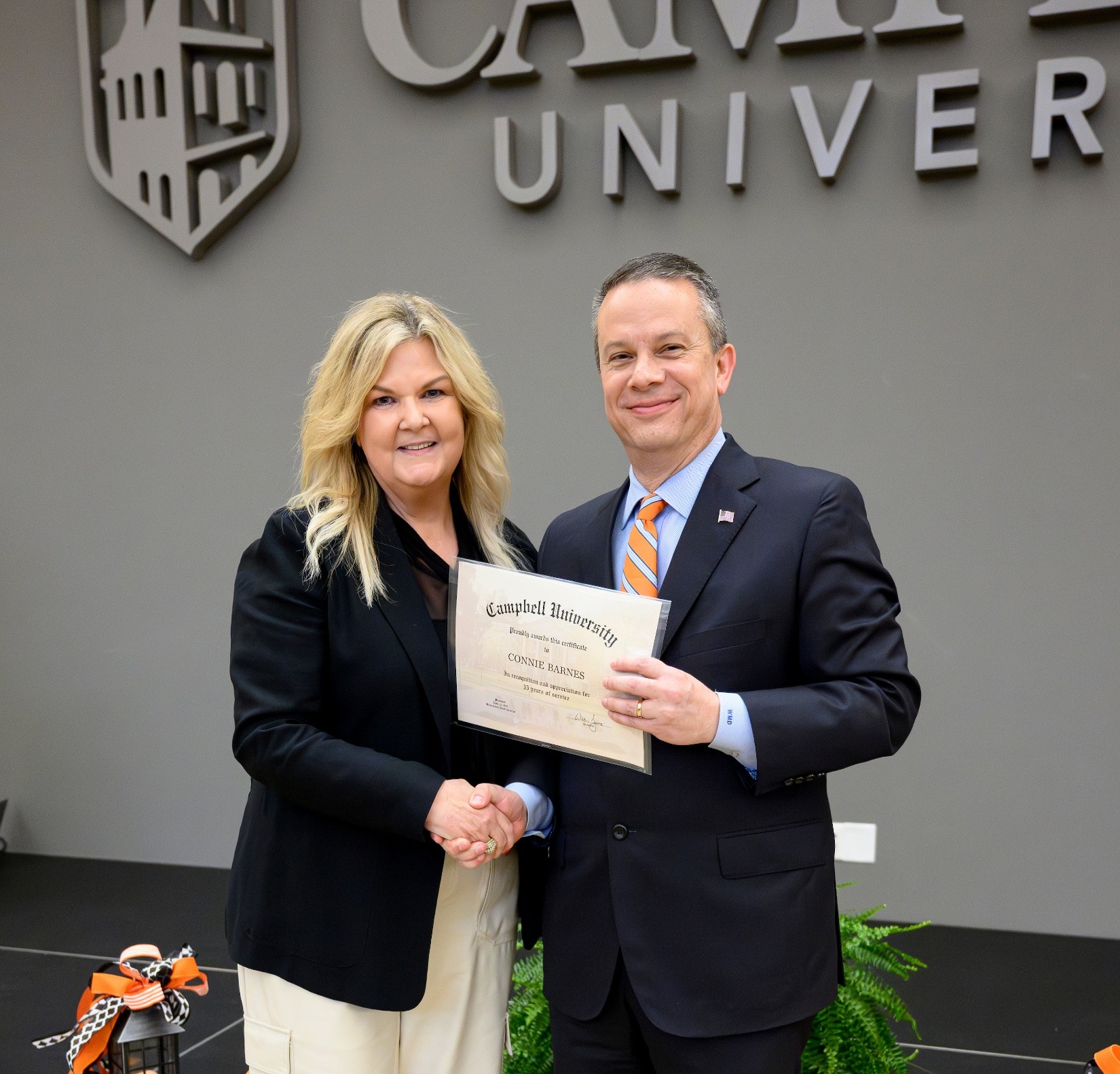 Dr. Barnes with President Downs shaking hands at the service anniversary ceremony.