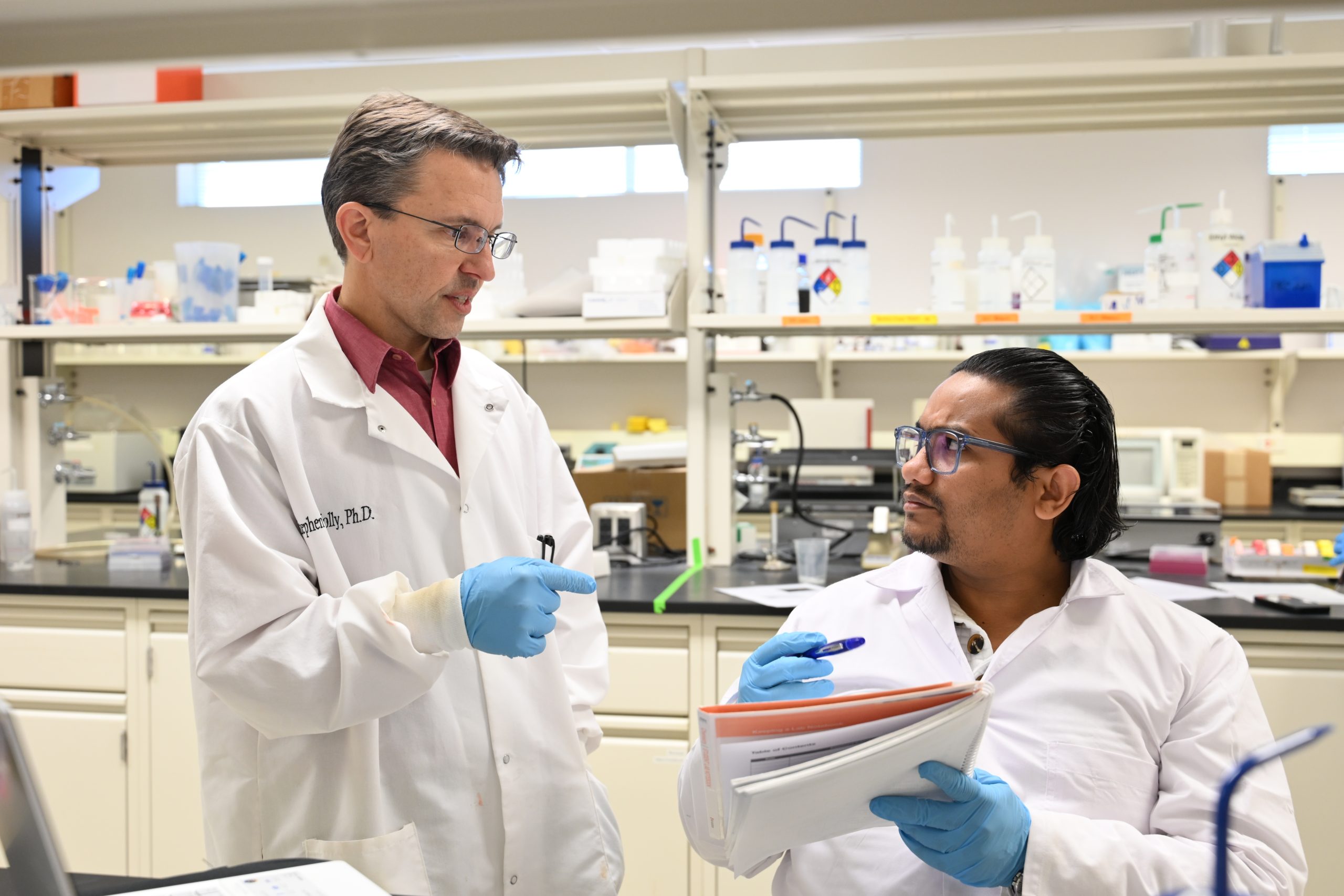 Faculty member talks with student in science lab