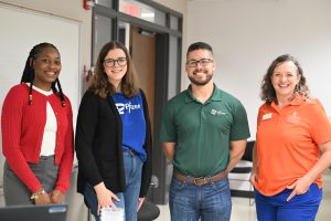 Employees from Pfizer stand with our Science Education Outreach coordinator in a lab