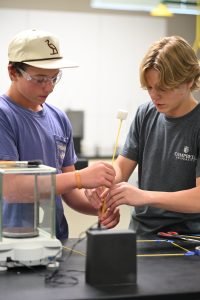 Two students building a spaghetti tower