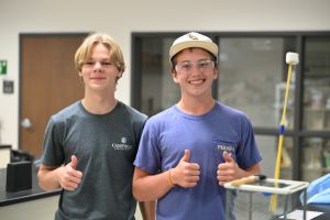 Two students with thumbs up