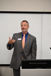 Speaker gestures to the crowd at the podium