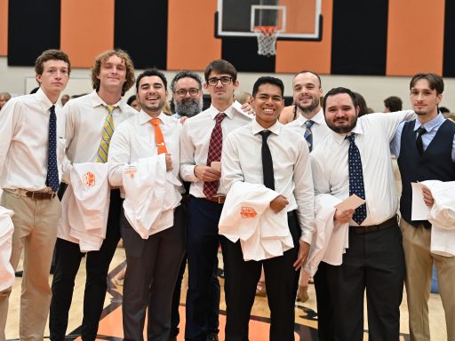 Male students holding their white coats
