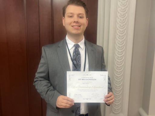 Photo of Campbell Law student Reed Ballus '27 holding his outstanding advocate award