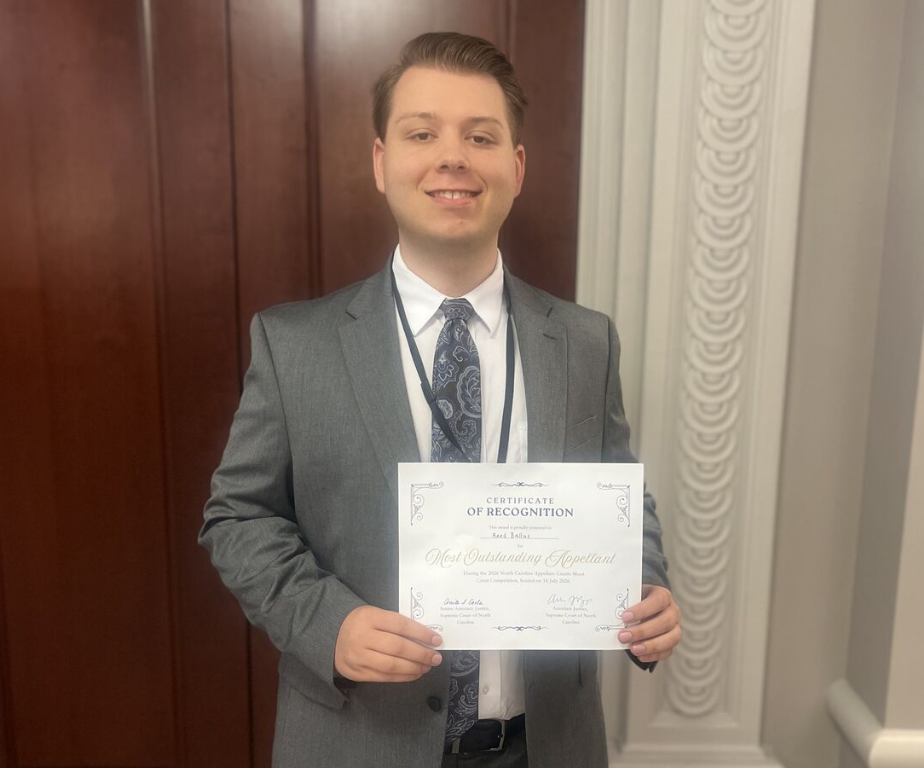 Photo of Campbell Law student Reed Ballus '27 holding his outstanding advocate award