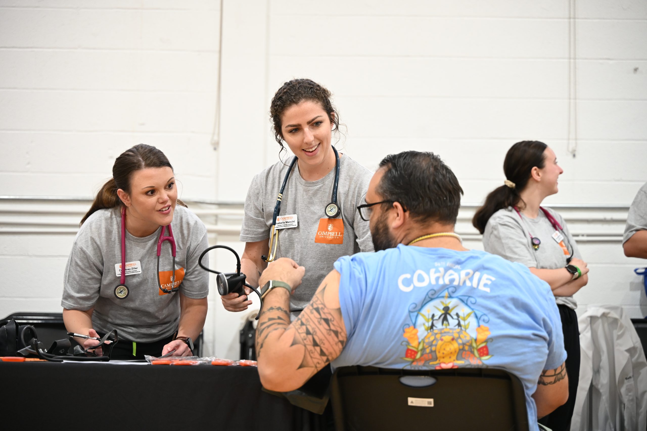 Students talking with community member at health fair.
