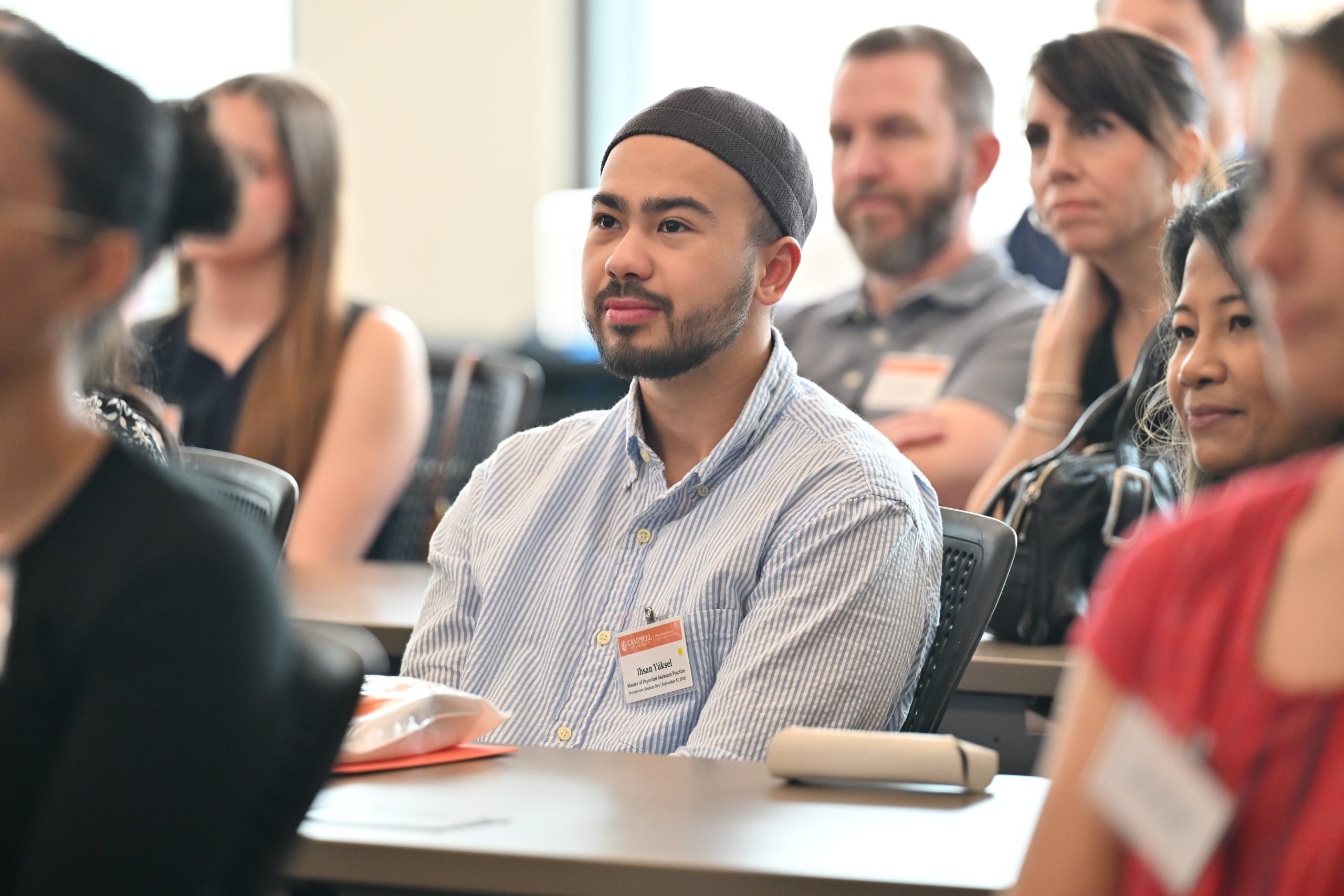 student looking up at speaker sitting in classroom with others