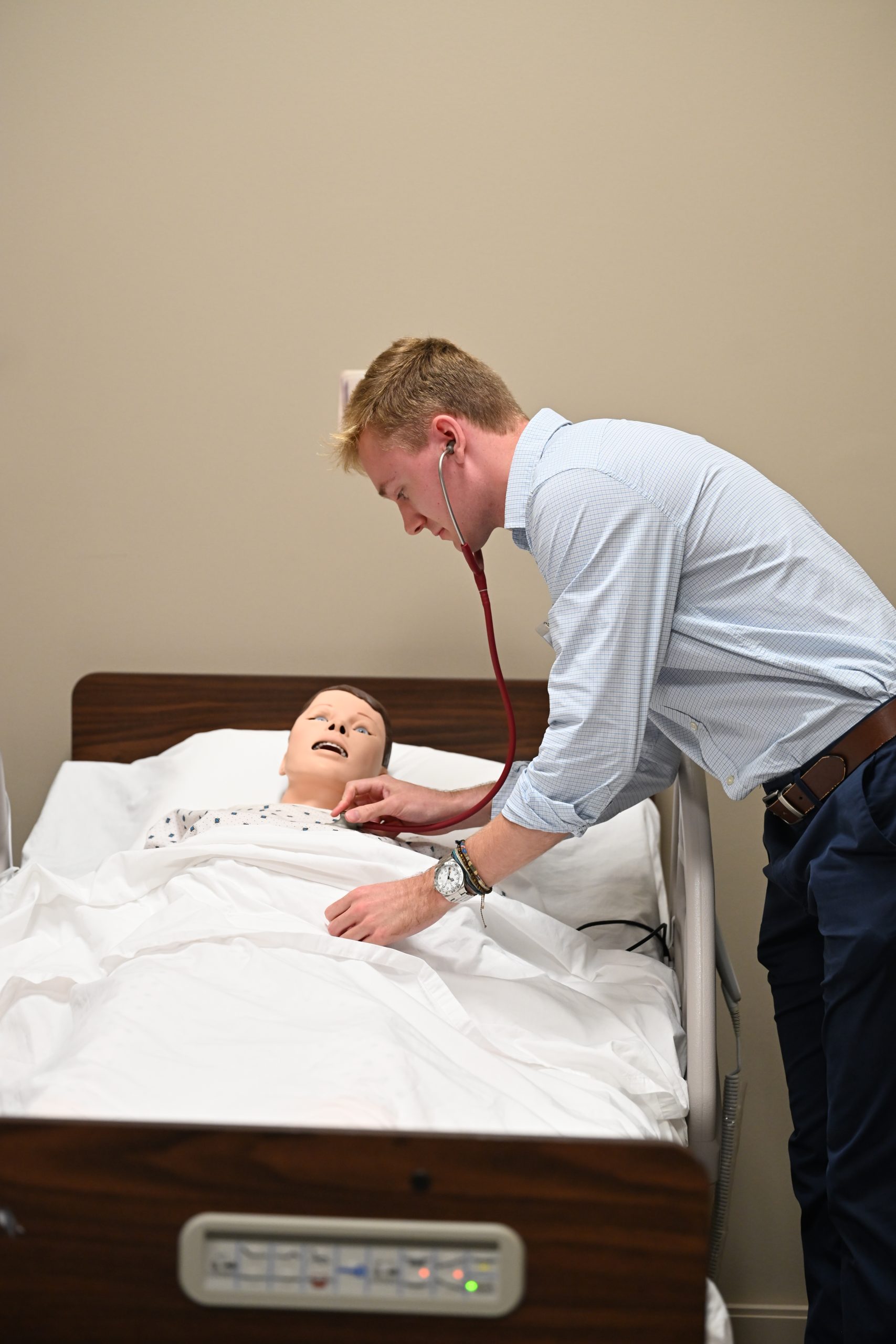 Student listing to chest of simulation mannequin