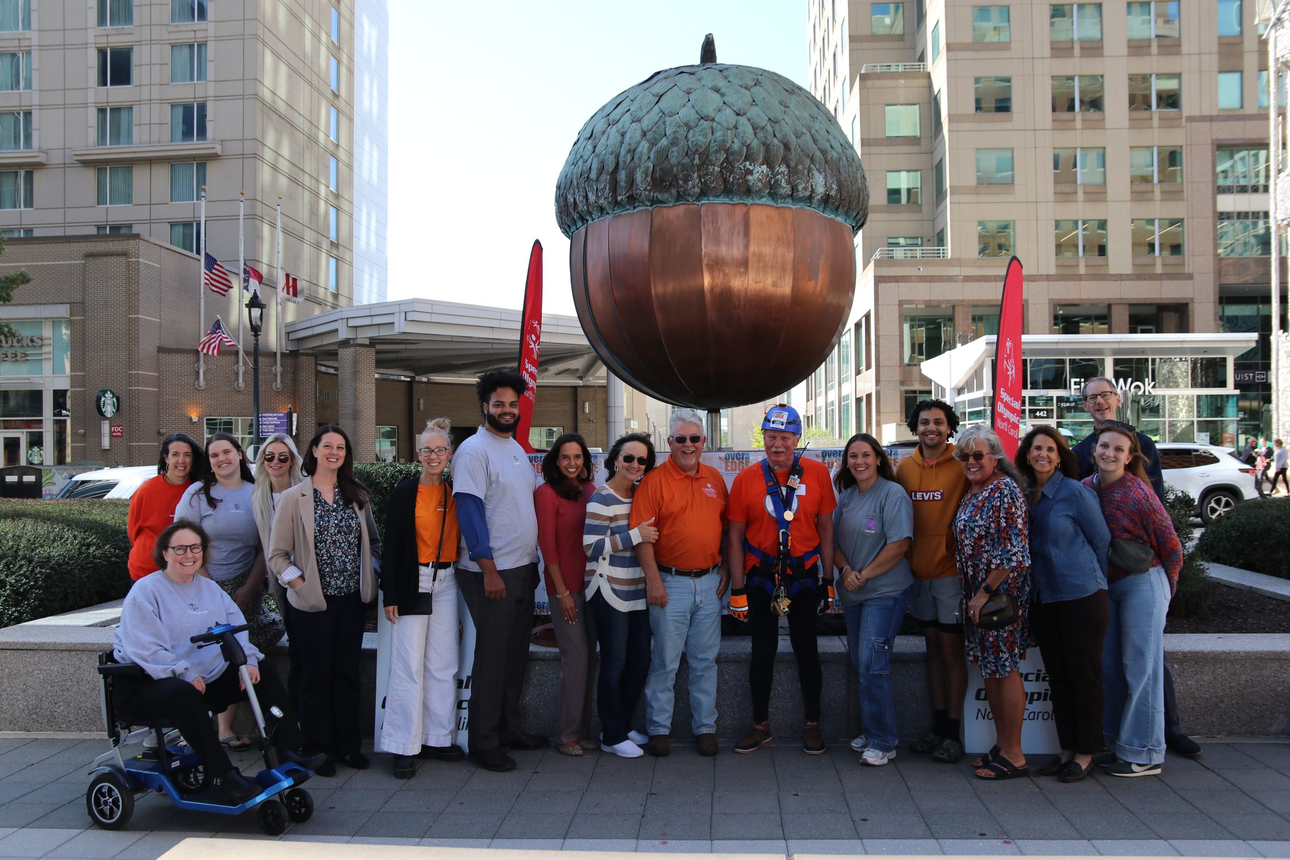 Photo of group of law students, faculty, staff and the dean under the acorn on the Fayetteville Street Plaza