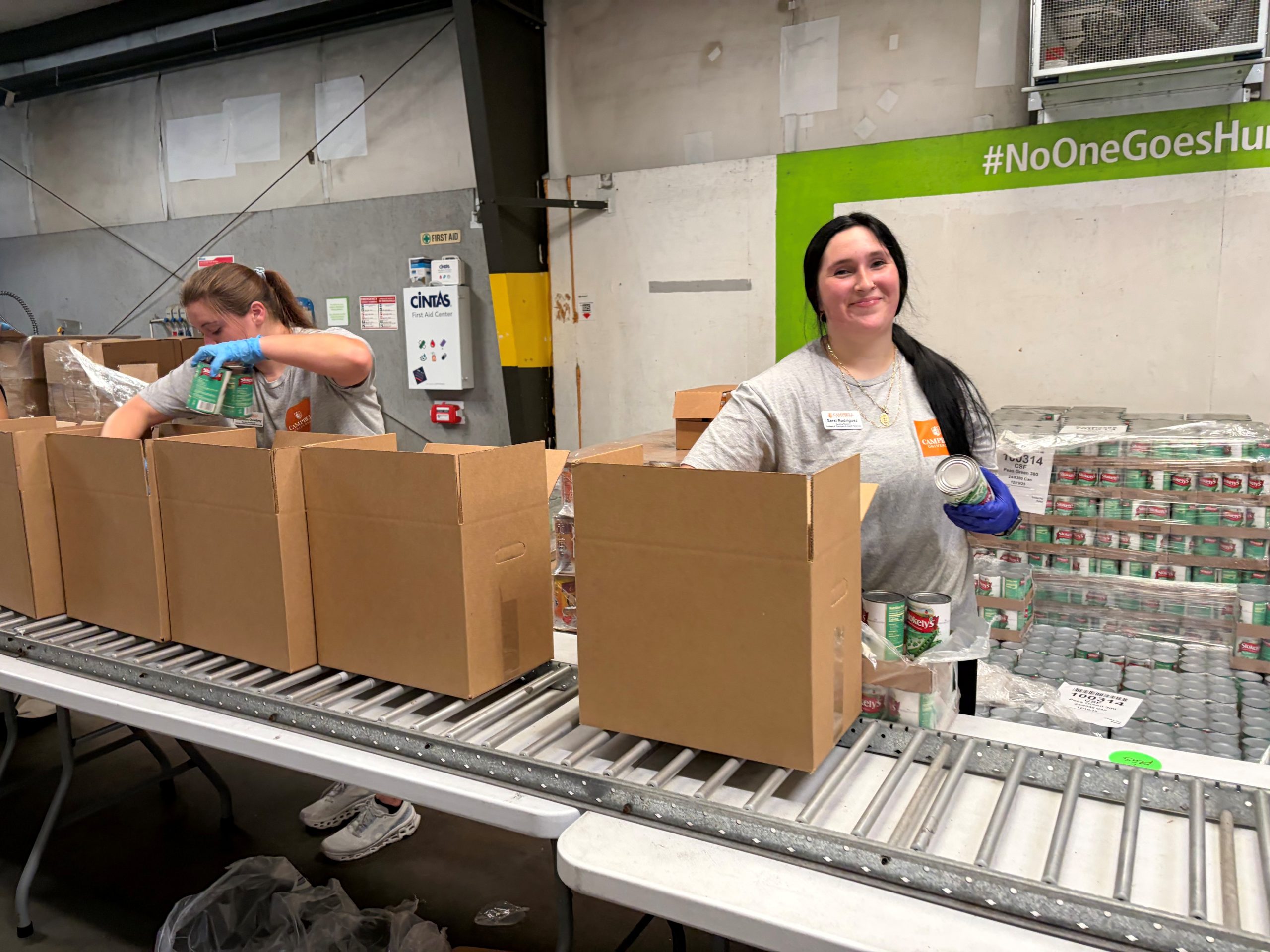Student packing cans in box.