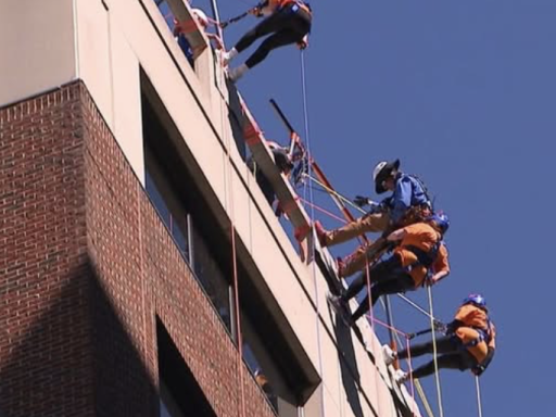 Photo of three Campbell Law students rapelling off the top of a building in downtown Raleigh
