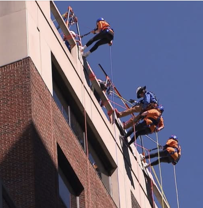 Photo of three Campbell Law students rapelling off the top of a building in downtown Raleigh