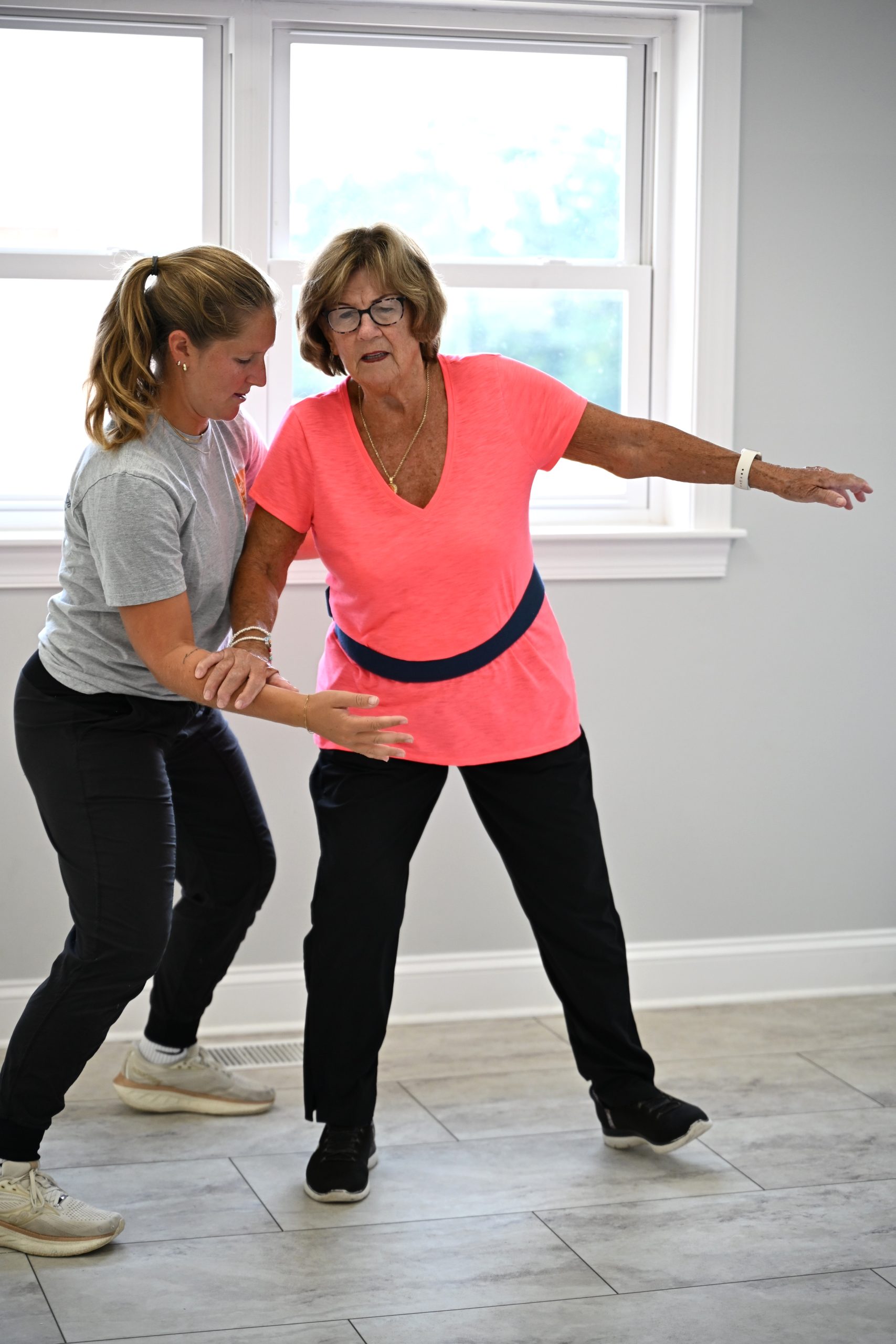 Student supporting senior adult during PT session