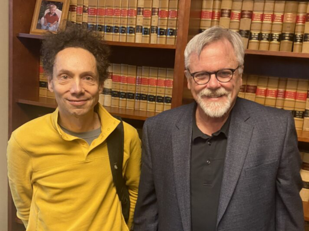 Photo of author Malcolm Gladwell and Professor Gregory Wallace in his office