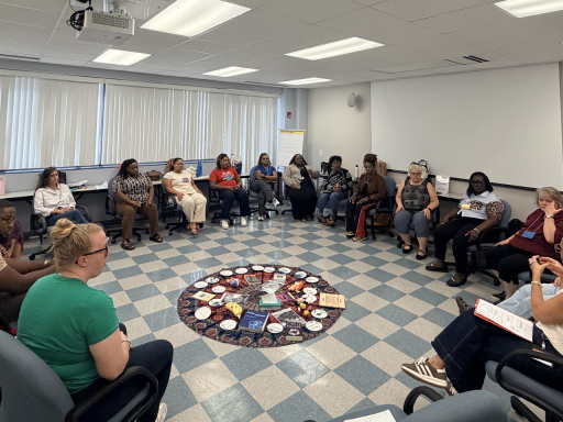 Photo of a large group of educators sitting in a circle in a conference room with Campbell Law Professor Jon Powell '98