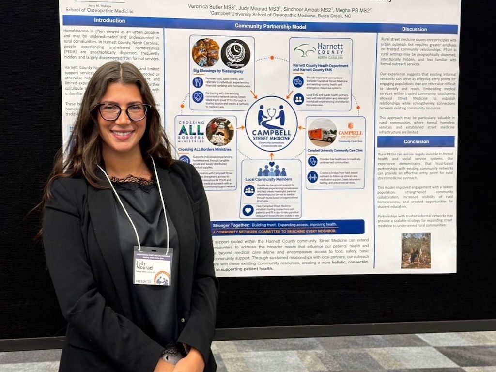 Photo of CUSOM student Dr. Judy Mourad, posing with research poster.