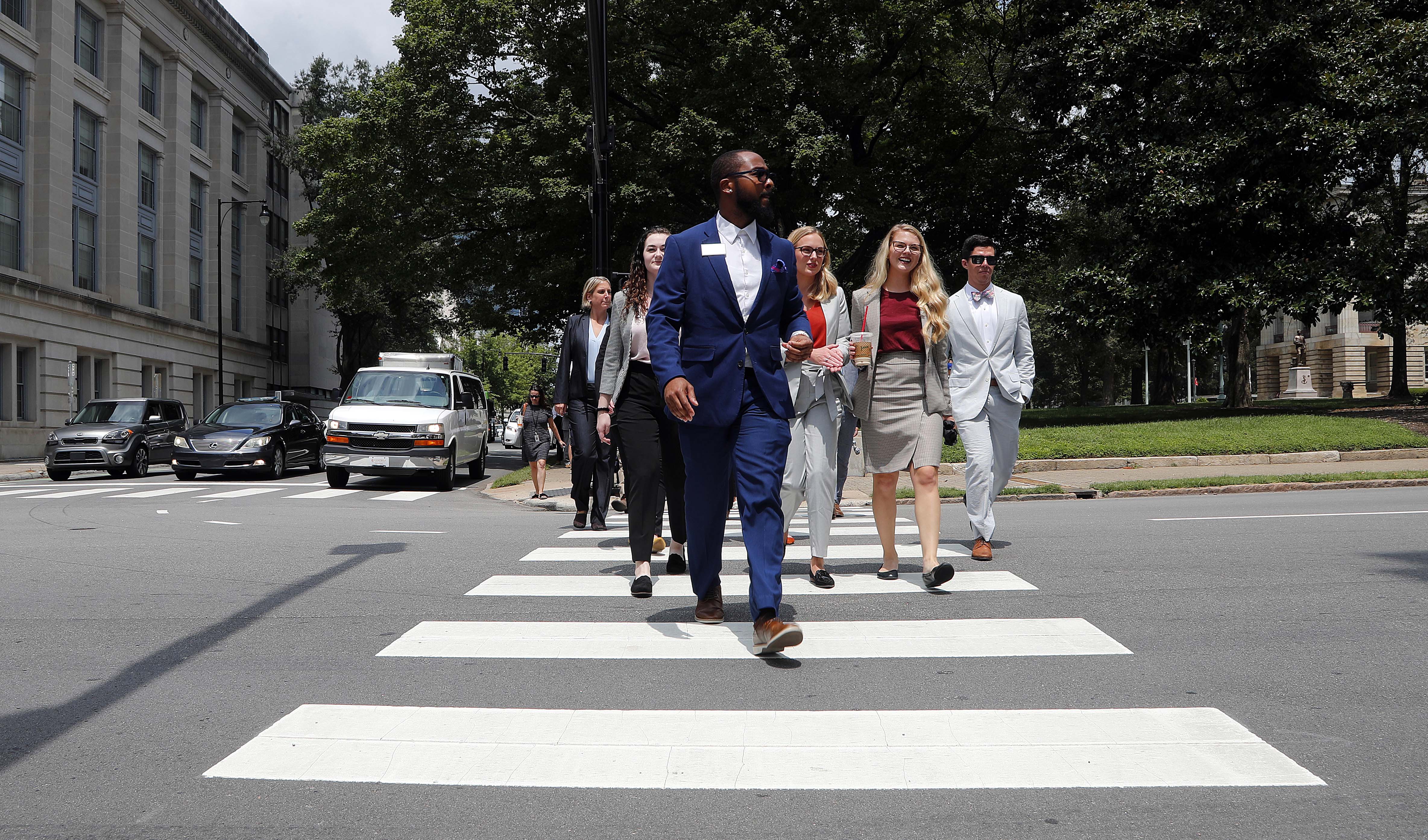 Photo of law students walking across a street on a crosswalk during the Dean's Court Crawl during orientation