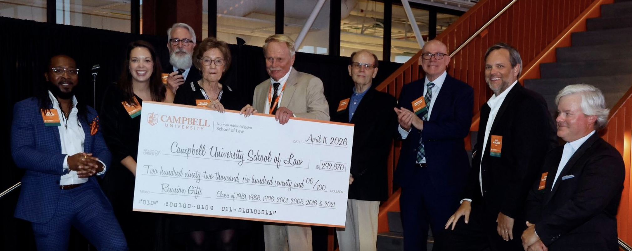 Photo of Campbell Law alumni with Dean Rich Leonard holding a large check in Raleigh's Union Station.