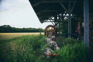 Old hay shelter with rustied farm tools