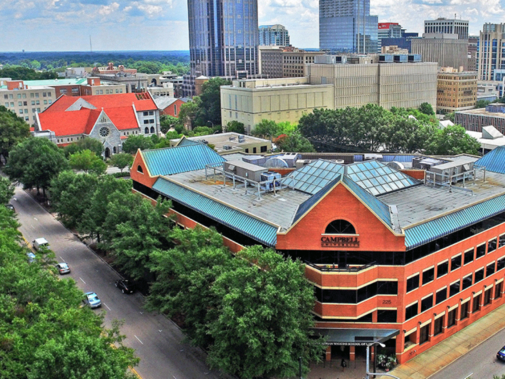 Photo of law school building exterior with Raleigh skyline in background