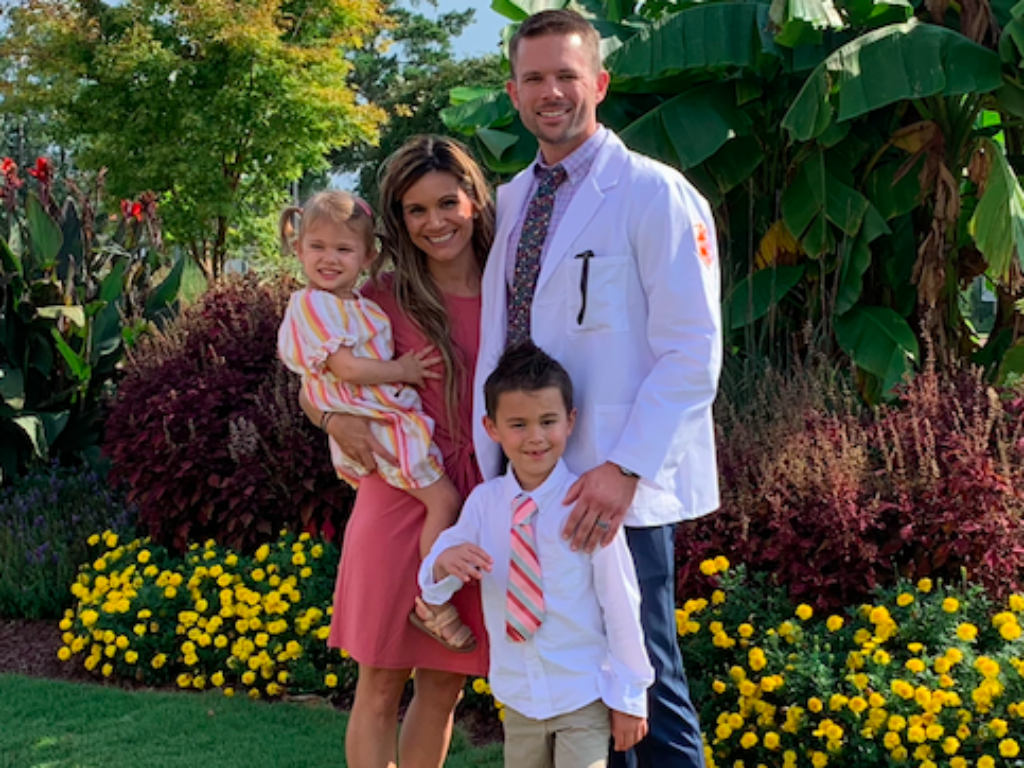 Sean Childress stands with wife and two kids