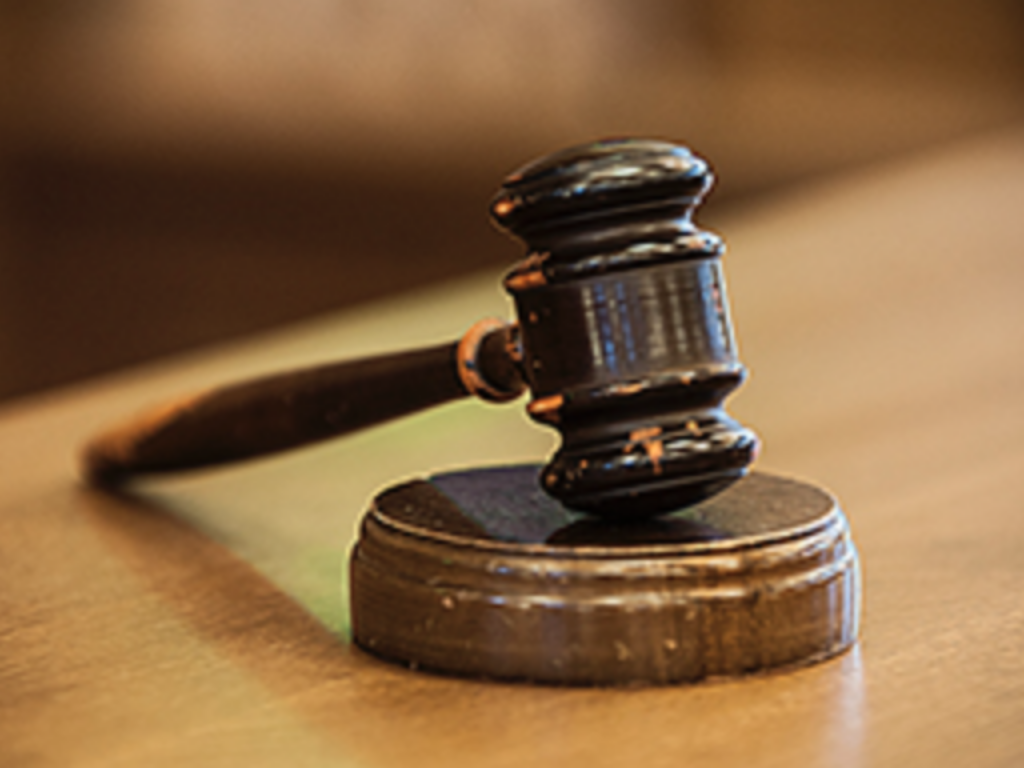 Photo of a wooden gavel on a courtroom bench